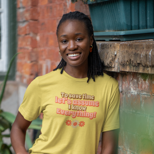 Woman shown is wearing our "Sarcastic Wisdom" T-Shirt from E H Creations. This retro-inspired design features the cheeky phrase "To save time, let's assume I know everything," on a maize yellow T-shirt.